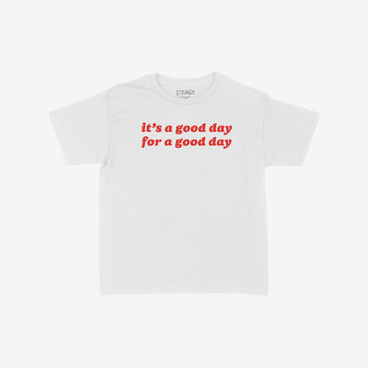 Good Day Women's Baby Tee features bold red text promoting positivity. This cropped, short-sleeve crew-neck T-shirt embodies retro optimism, aligning with a spirit of equality and inclusivity.