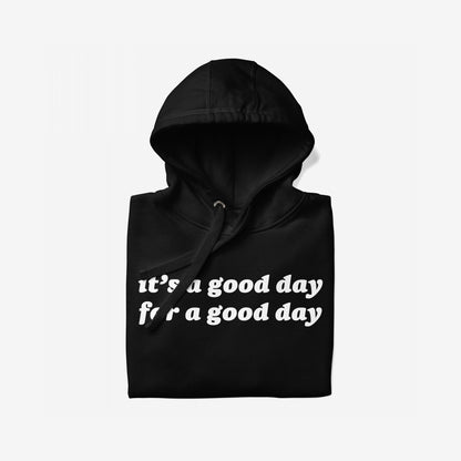 Black pullover hoodie, hood up, with bold white text: It’s a good day for a good day. The Good Day Hoodie & Sweatshirt embodies optimism and comfort, perfect for starting your day positively.