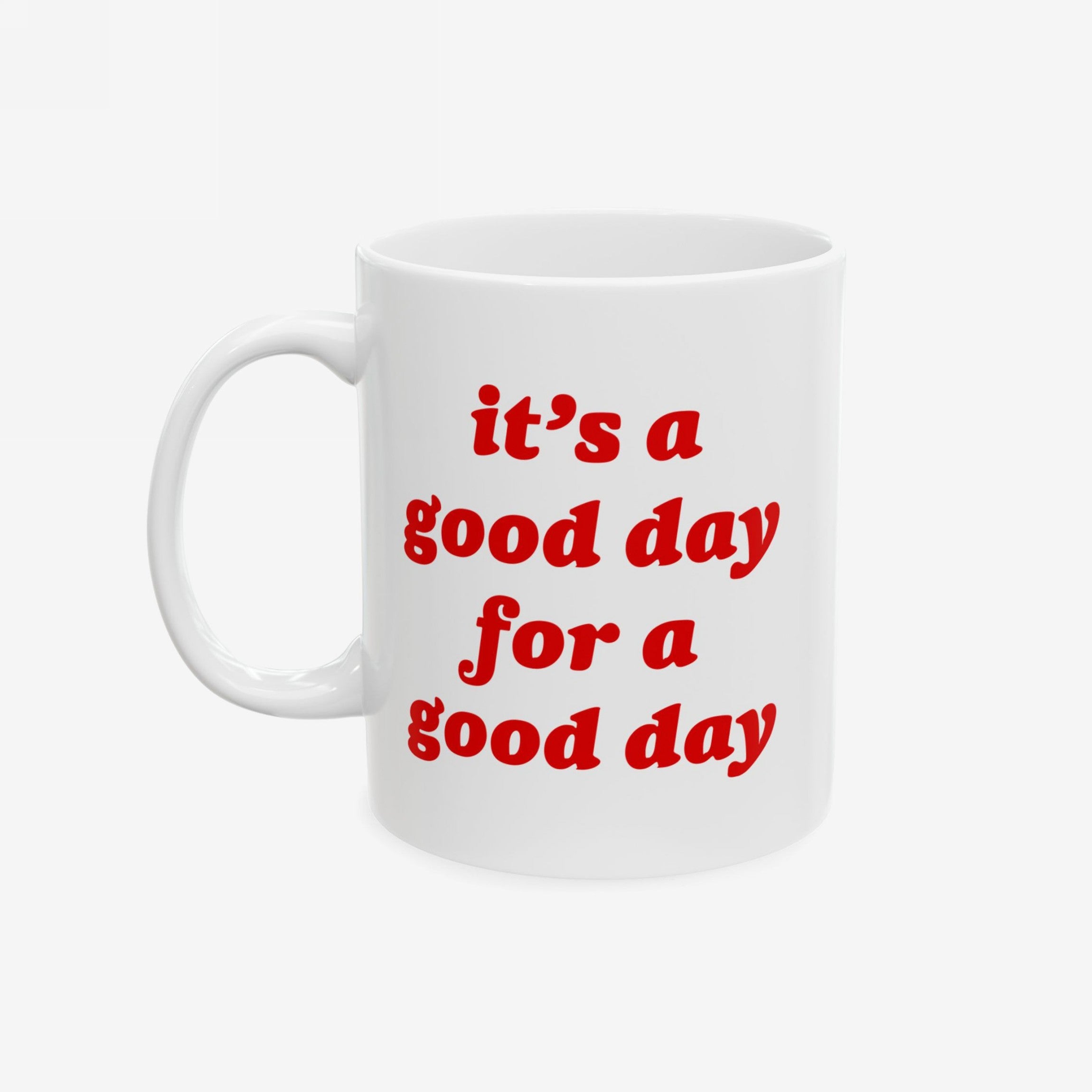 The Good Day Mug features a playful, bold red slogan on white ceramic, advocating positivity with a hint of sarcasm; ideal for those needing an optimistic start, available in two sizes.