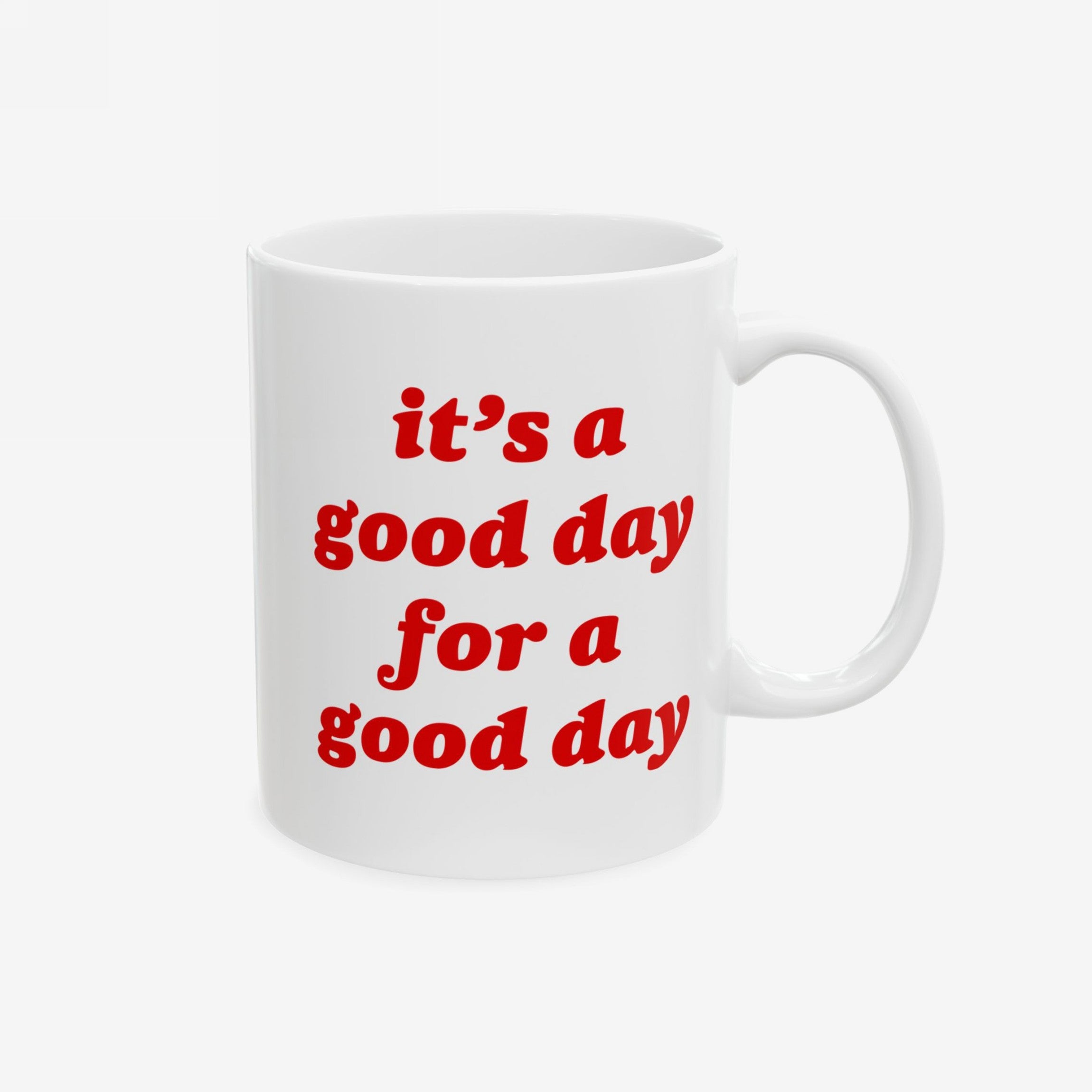 The Good Day Mug features a red slogan, “it’s a good day for a good day,” on a white ceramic surface, designed for the mindful or sarcastically optimistic. Available in 11 oz. and 15 oz. sizes.