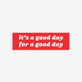 Good Day Sticker & Magnet displayed over a bustling crowd scene, featuring the message it’s a good day for a good day with options for either a sticker or magnet design.