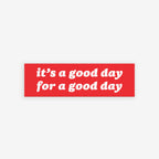 Good Day Sticker & Magnet displayed over a bustling crowd scene, featuring the message it’s a good day for a good day with options for either a sticker or magnet design.