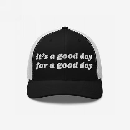 The Good Day Hat features a black front and brim with white mesh panels, showcasing it's a good day for a good day in white embroidery, embodying positive vibes and mental health advocacy.