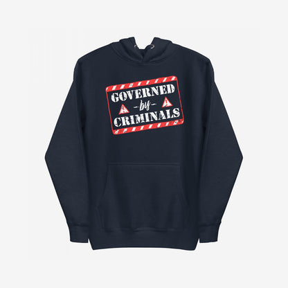 Navy-blue Governed By Criminals Hoodie features a red warning-stripe box with a bold stencil slogan, front kangaroo pocket, and drawstrings, embodying protest and resistance against hypocrisy and corruption.
