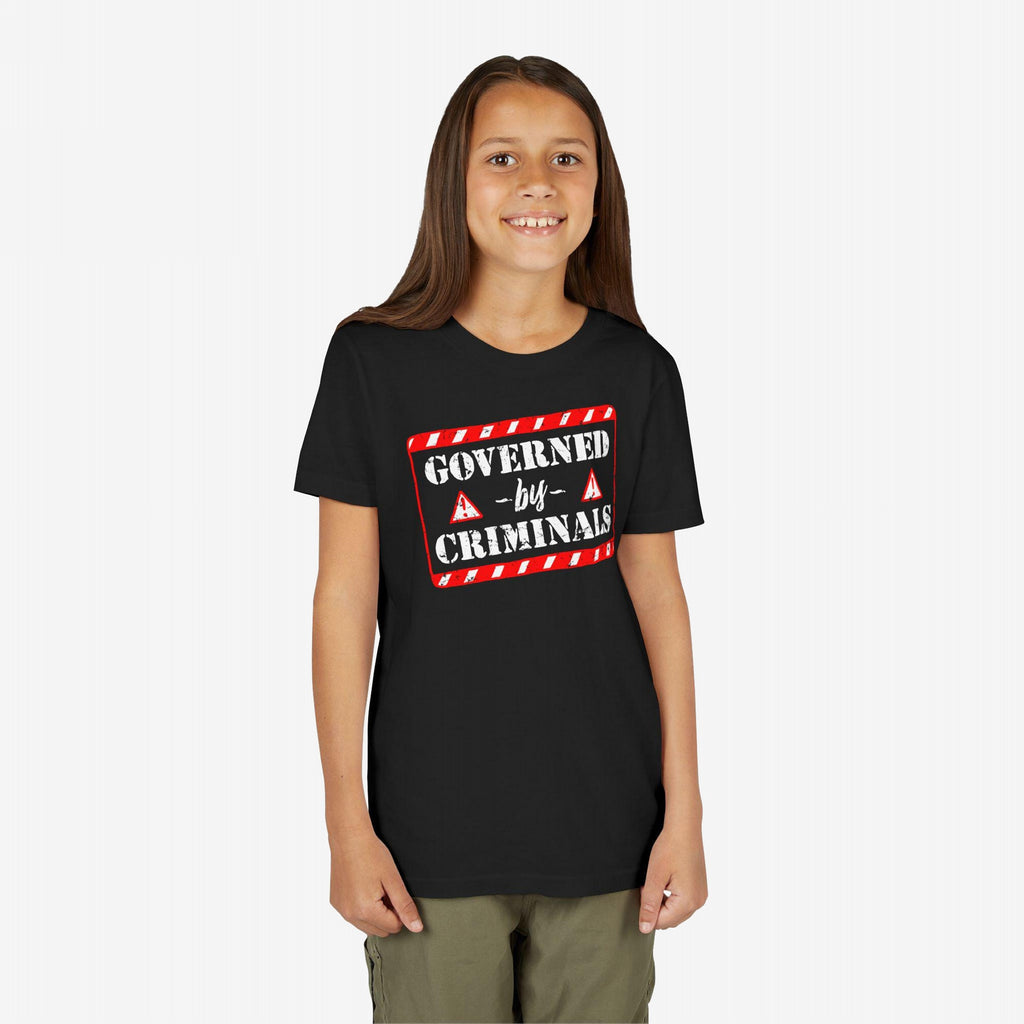 Young girl with long brown hair wears the Governed By Criminals Shirt, featuring a bold, red-and-white warning graphic, embodying a rebellious stance against political corruption.