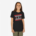 Young girl with long brown hair wears the Governed By Criminals Shirt, featuring a bold, red-and-white warning graphic, embodying a rebellious stance against political corruption.