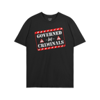 Black T-shirt featuring a bold graphic with red-and-white hazard stripes reading “GOVERNED by CRIMINALS,” alongside warni