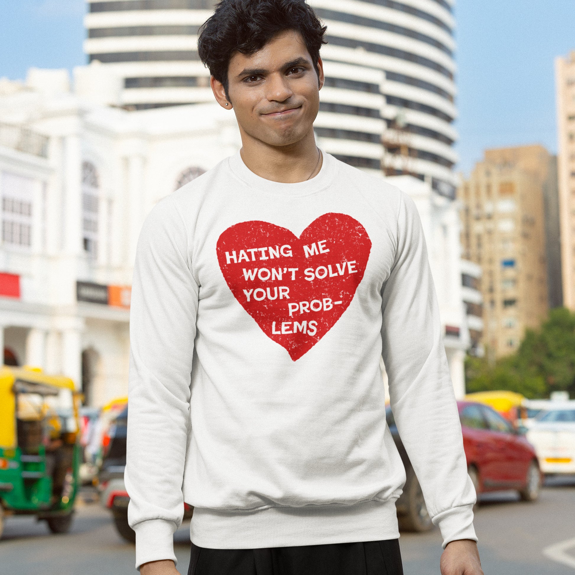 Young man in a city street wearing the No Hate Shirt featuring a large red heart with the message “Hating Me Won’t Solve Your Problems,” supporting equality and justice causes.