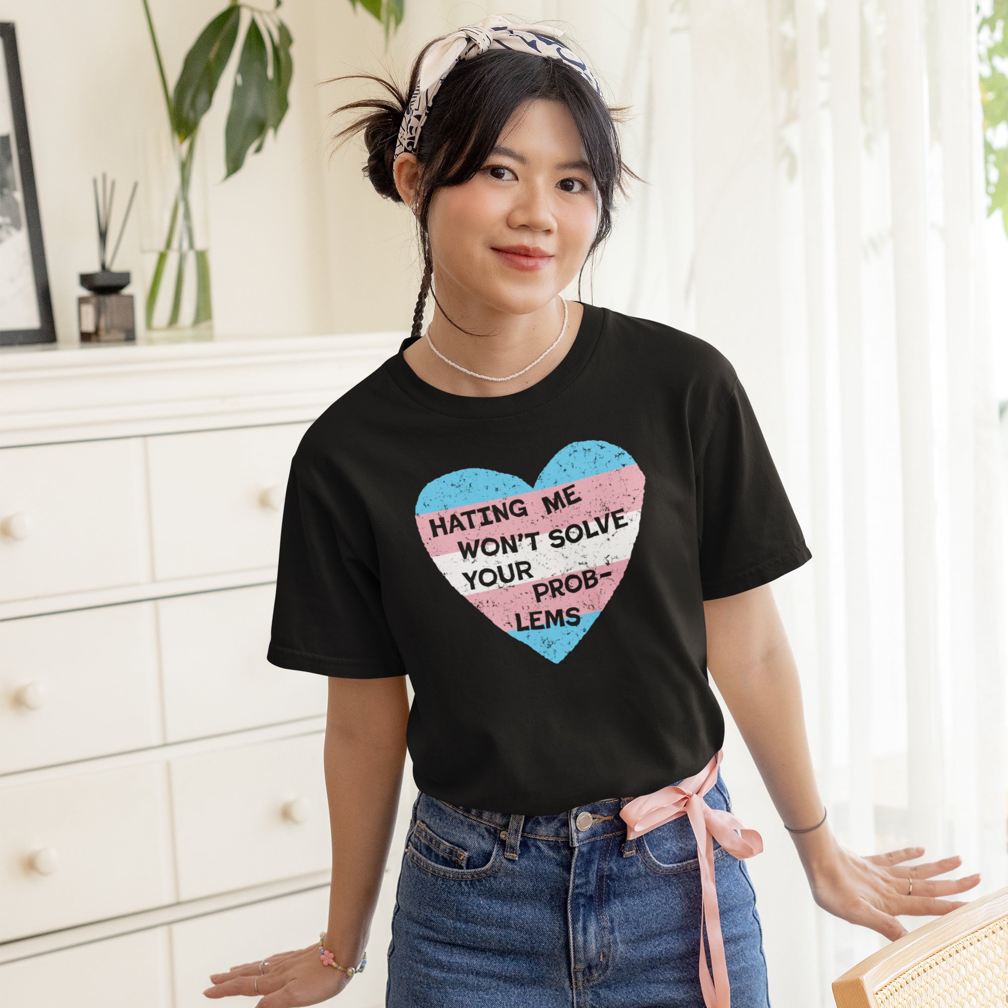 Young person wearing the No Trans Hate Shirt with a distressed heart graphic and slogan, styled with high-waisted jeans and a headband, embodying trans pride and visibility.