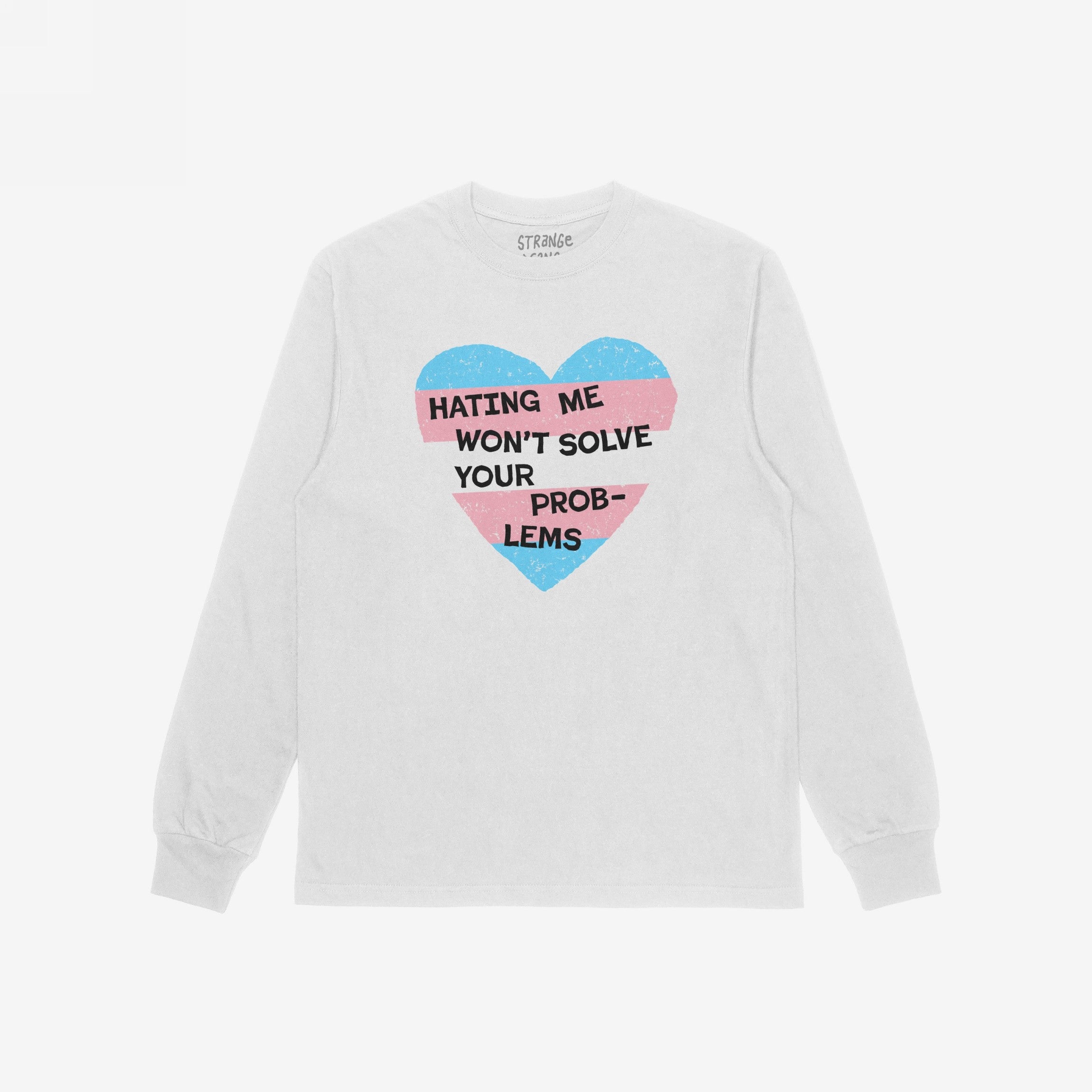White long-sleeve No Trans Hate Shirt with a heart in pastel blue and pink stripes, featuring the slogan “Hating Me Won’t Solve Your Problems,” promoting trans visibility and pride.