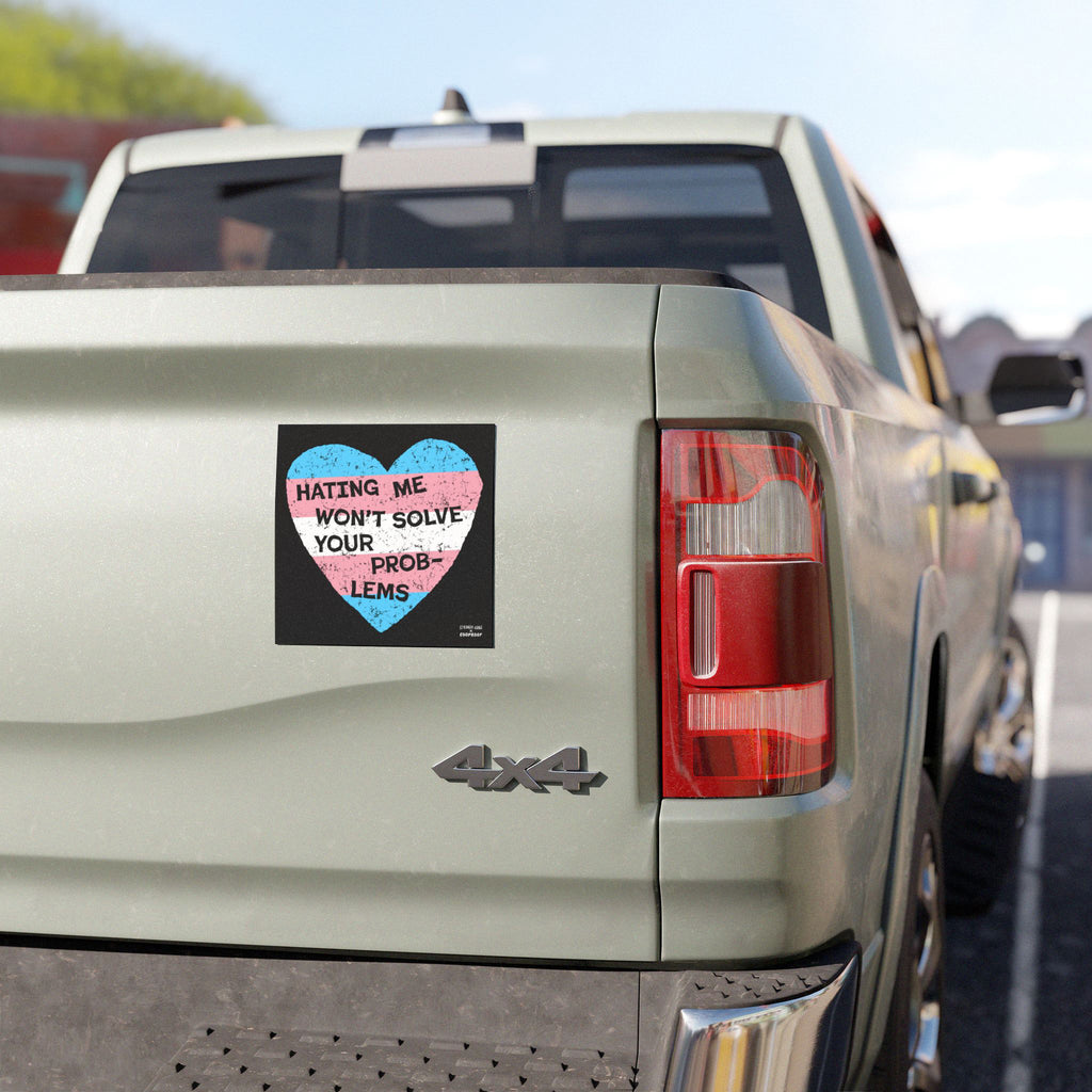 Rear view of a light-colored 4x4 pickup truck featuring the No Trans Hate Sticker & Magnet with a trans pride heart and empowering message against transphobia displayed prominently on the tailgate.