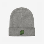 The Hop Nug Hat is a light-gray rib-knit beanie with a folded cuff, featuring a green hop cone embroidered on the center, perfect for craft beer enthusiasts with casual confidence.