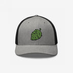 Hop Nug Hat: A stylish trucker cap with a gray front and black mesh back, featuring an embroidered green hop cone. Ideal for craft beer enthusiasts who appreciate casual, confident style.