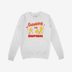The Hopium Shirt features a white crewneck sweatshirt with Surviving on HOPIUM in bold red and yellow, plus three yellow cartoon figures, embodying whimsical defiance and idealistic optimism.