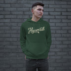 Young man wearing the Hopsmash Hoodie, featuring a forest-green pullover with Hopsmash script and hop-cone graphic, standing confidently, embodying a bold statement of hop appreciation.