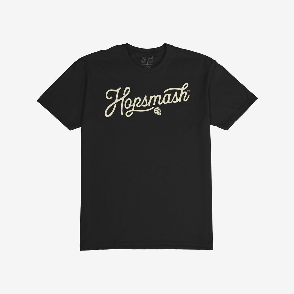 Hopsmash T-shirt: Black short-sleeved tee with “Hopsmash” in cream cursive across the chest, featuring a hop cone icon. Perfect for craft beer enthusiasts who embrace boldness and individuality.