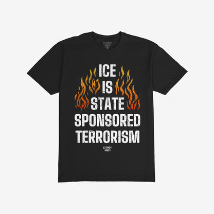 Black T-shirt with bold graphic reading “ICE IS STATE SPONSORED TERRORISM” in distressed white text, flanked by orange-yellow flames, conveying a strong message against cruelty at the border.