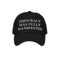 Black baseball-style cap featuring the bold embroidered text IDIOCRACY HAS FULLY MANIFESTED in classic serif type, blending s