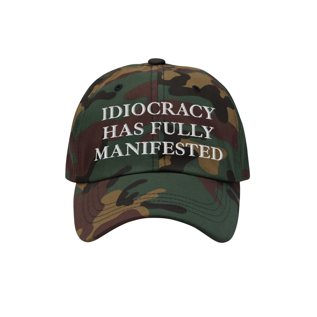 Camouflage-patterned Idiocracy Hat with white embroidered text declaring, IDIOCRACY HAS FULLY MANIFESTED, offering bold socia
