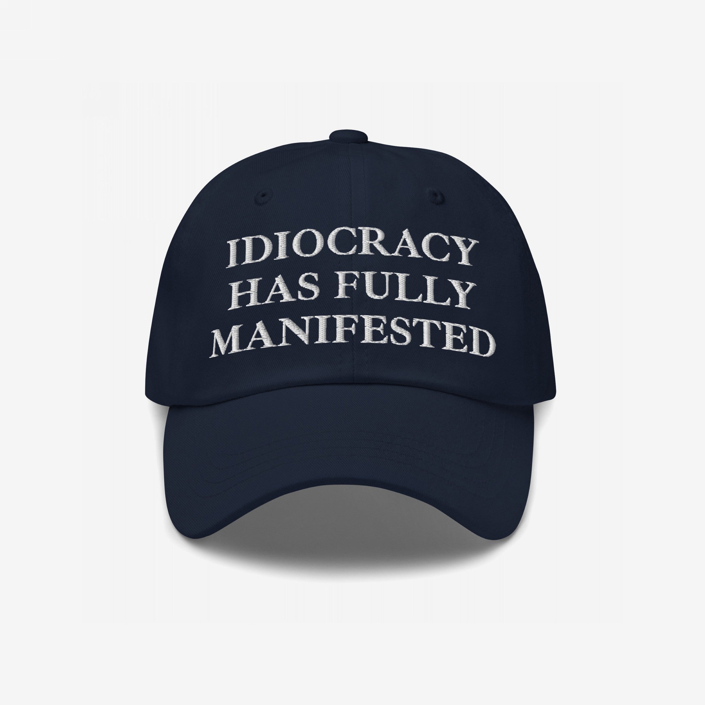 Navy-blue Idiocracy Hat with IDIOCRACY HAS FULLY MANIFESTED embroidered in white serif letters, reflecting bold social commentary and aligning with the store's advocacy for equality and justice.