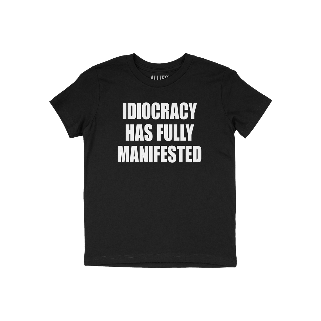 Black crew-neck T-shirt featuring the slogan IDIOCRACY HAS FULLY MANIFESTED in bold white letters, conveying a satirical and 