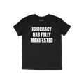 Black crew-neck T-shirt featuring the slogan IDIOCRACY HAS FULLY MANIFESTED in bold white letters, conveying a satirical and 