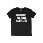 Black crew-neck T-shirt featuring the slogan IDIOCRACY HAS FULLY MANIFESTED in bold white letters, conveying a satirical and 