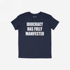 The Idiocracy T-shirt features a bold white slogan declaring “IDIOCRACY HAS FULLY MANIFESTED,” capturing the essence of modern disillusionment and cultural critique.