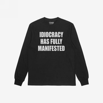 Black long-sleeve Idiocracy T-shirt features bold white text stating, IDIOCRACY HAS FULLY MANIFESTED, embodying a blunt societal critique. The brand label, STRANGE ALLIES, is visible inside.