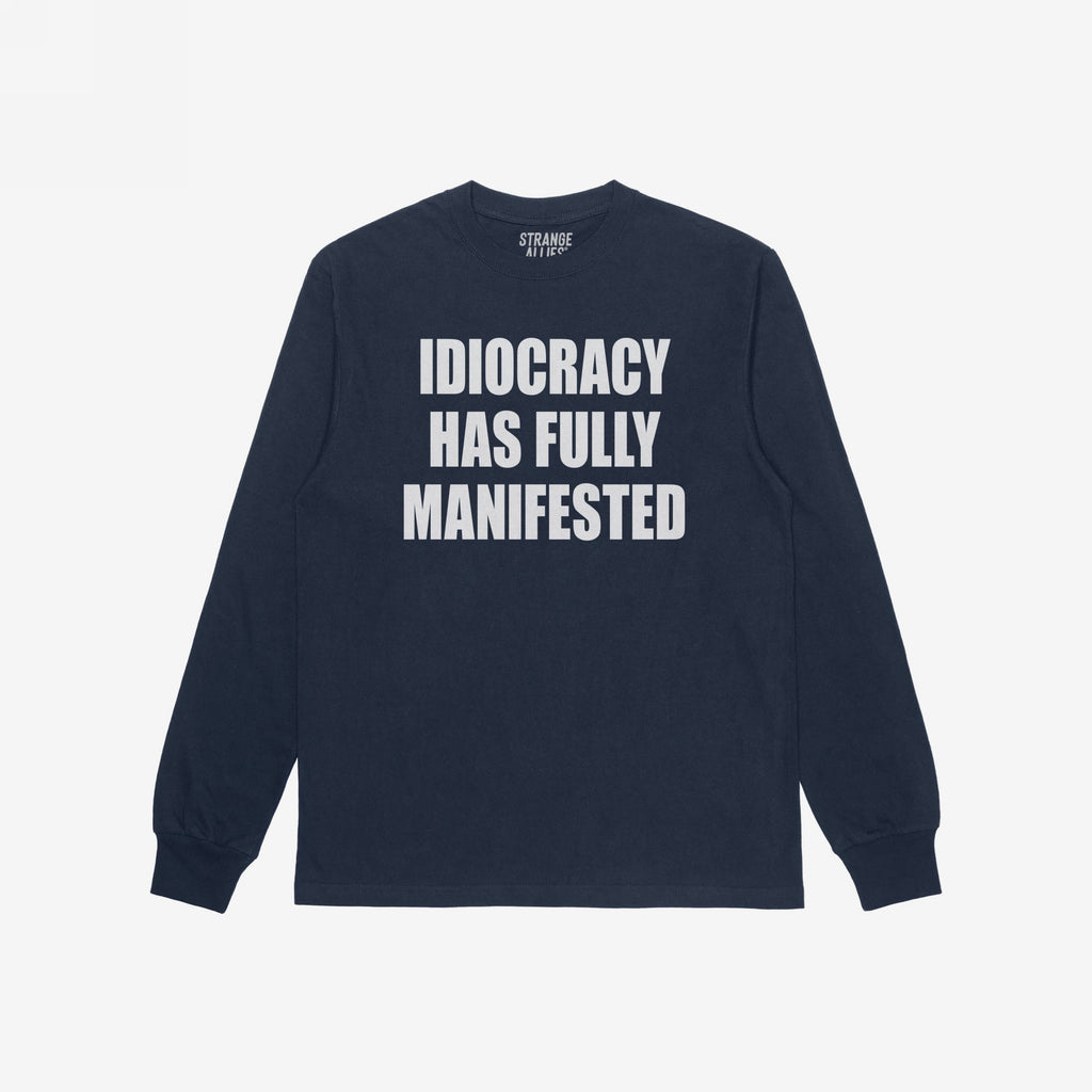 Navy-blue Idiocracy T-shirt with “IDIOCRACY HAS FULLY MANIFESTED.” printed in white on the front, reflecting a bold, political statement.