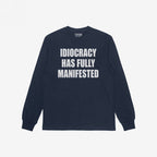 Navy-blue Idiocracy T-shirt with “IDIOCRACY HAS FULLY MANIFESTED.” printed in white on the front, reflecting a bold, political statement.