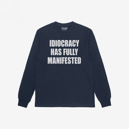 Navy-blue Idiocracy T-shirt with “IDIOCRACY HAS FULLY MANIFESTED.” printed in white on the front, reflecting a bold, political statement.