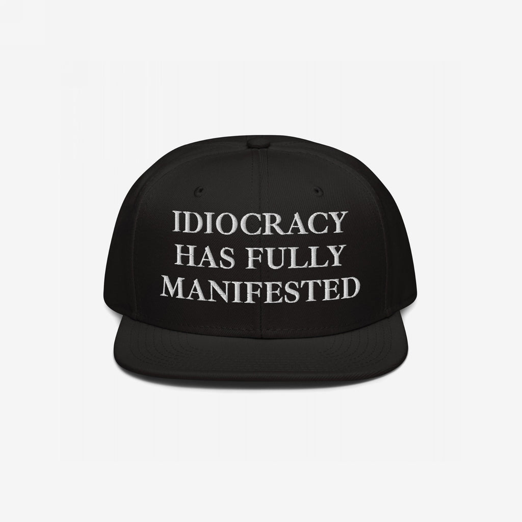 Black snap-back baseball cap with white serif text: “IDIOCRACY HAS FULLY MANIFESTED.” The Idiocracy Hat delivers bold social commentary, ideal for those who wear their beliefs front and center.