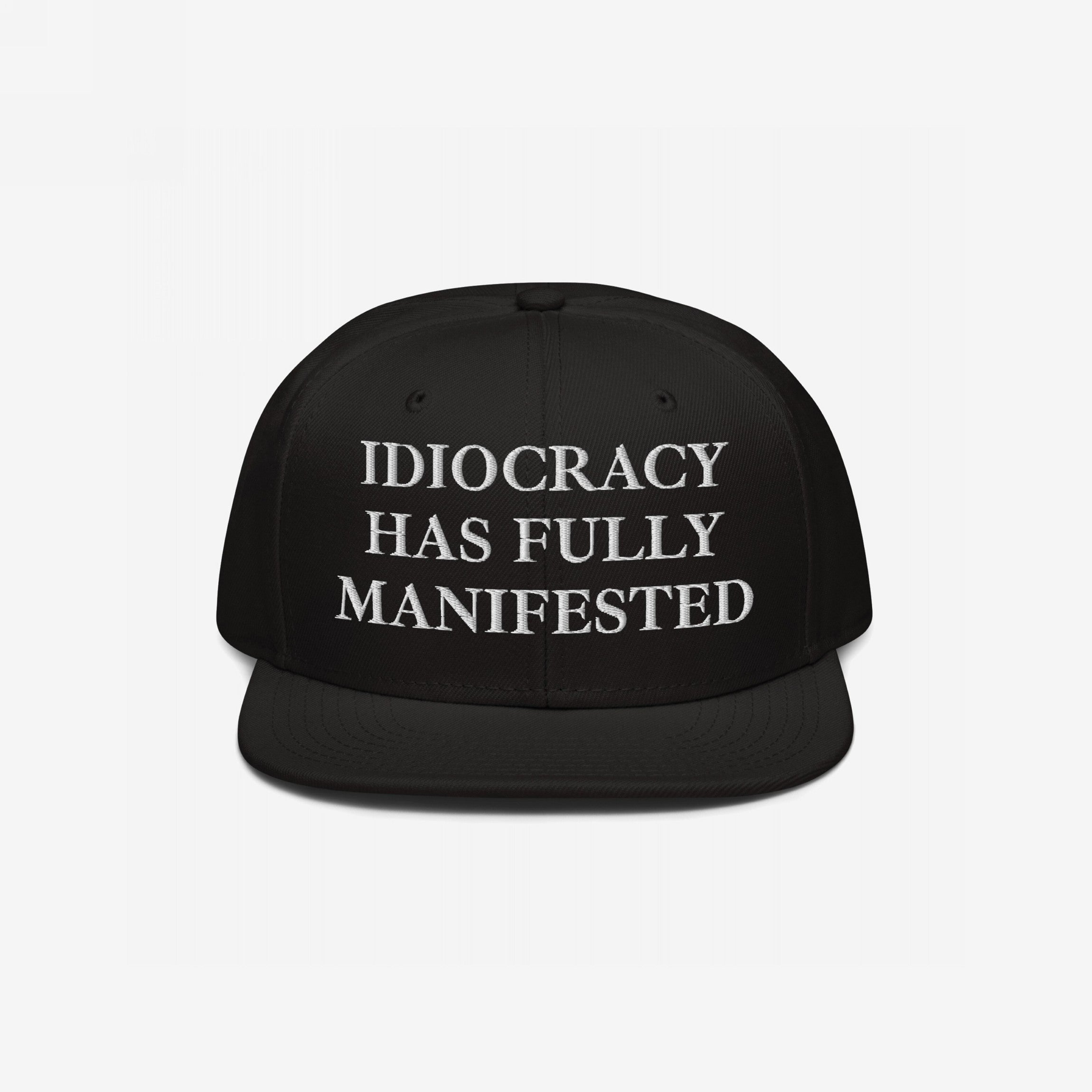 Black snap-back baseball cap with white serif text: “IDIOCRACY HAS FULLY MANIFESTED.” The Idiocracy Hat delivers bold social commentary, ideal for those who wear their beliefs front and center.
