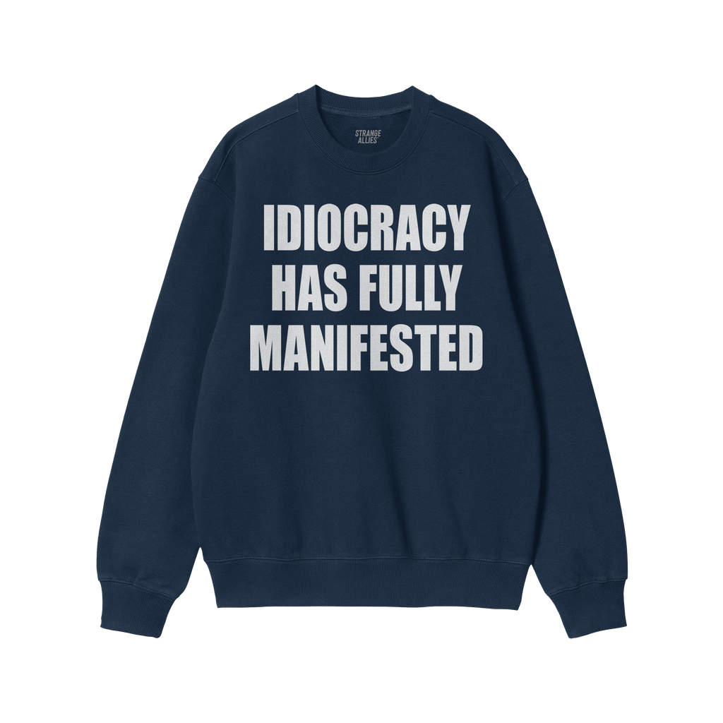 The Idiocracy Sweatshirt features bold white text declaring “IDIOCRACY HAS FULLY MANIFESTED” on a navy-blue crewneck, sym