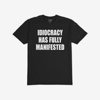 The Idiocracy T-shirt features bold white text stating “IDIOCRACY HAS FULLY MANIFESTED,” expressing a stark, satirical commentary. Ideal for those embracing sharp societal critiques with style.