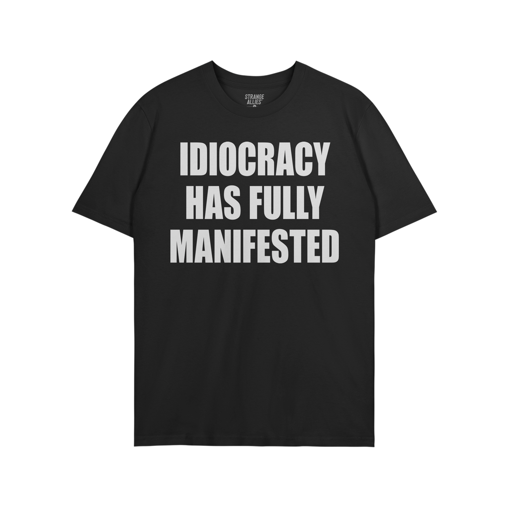The Idiocracy T-shirt features bold white text stating “IDIOCRACY HAS FULLY MANIFESTED,” expressing a stark, satirical co