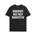 The Idiocracy T-shirt features bold white text stating “IDIOCRACY HAS FULLY MANIFESTED,” expressing a stark, satirical co