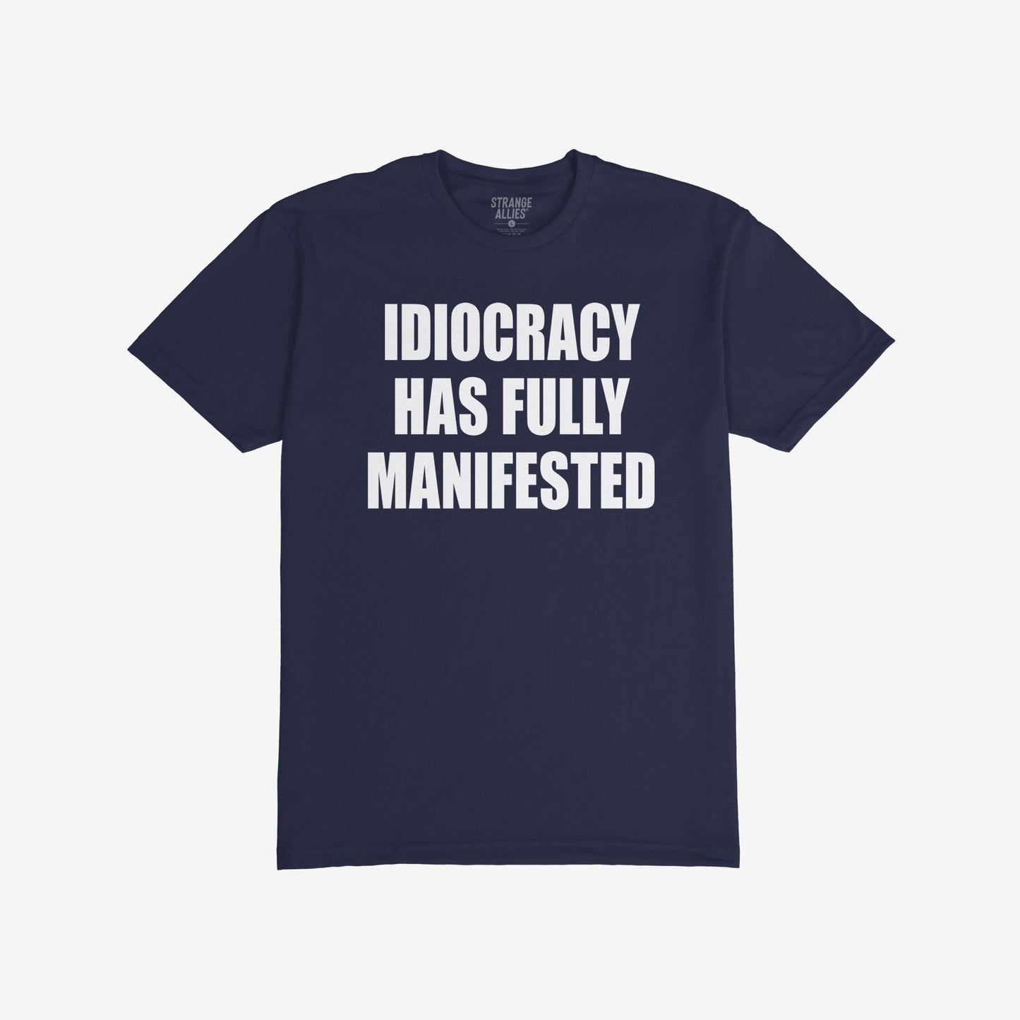 The Idiocracy T-shirt showcases bold white text stating IDIOCRACY HAS FULLY MANIFESTED on a dark-navy background, reflecting a sharp social commentary for the politically disillusioned.