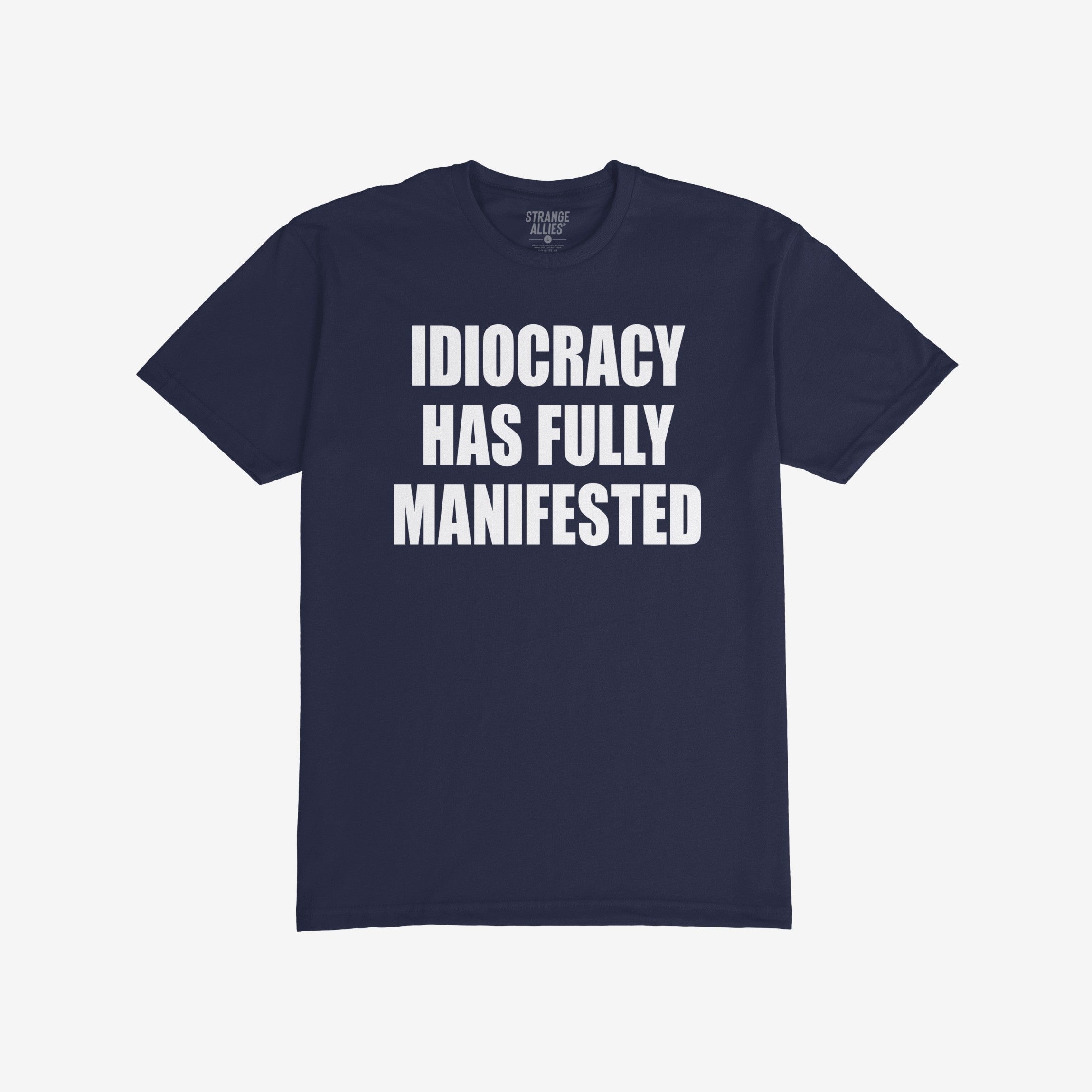 The Idiocracy T-shirt showcases bold white text stating IDIOCRACY HAS FULLY MANIFESTED on a dark-navy background, reflecting a sharp social commentary for the politically disillusioned.