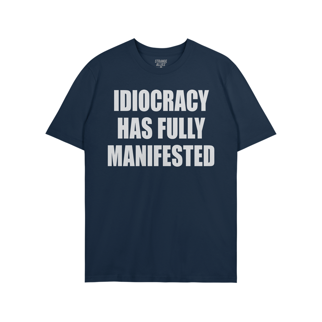 The Idiocracy T-shirt showcases bold white text stating IDIOCRACY HAS FULLY MANIFESTED on a dark-navy background, reflecting 