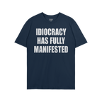 The Idiocracy T-shirt showcases bold white text stating IDIOCRACY HAS FULLY MANIFESTED on a dark-navy background, reflecting 