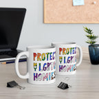 Protect My LGBTQ+ Homies Mug on a wood desk beside a laptop and stationery, showcasing bold, rainbow-colored lettering that promotes LGBTQ+ support, ideal for everyday use and gifting.