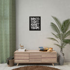 Born To Fight Against Fascism Graffiti Poster hangs above a mid-century sideboard, paired with books, a deer figurine, candles, and a palm frond, embodying protest spirit in a minimalist setting.