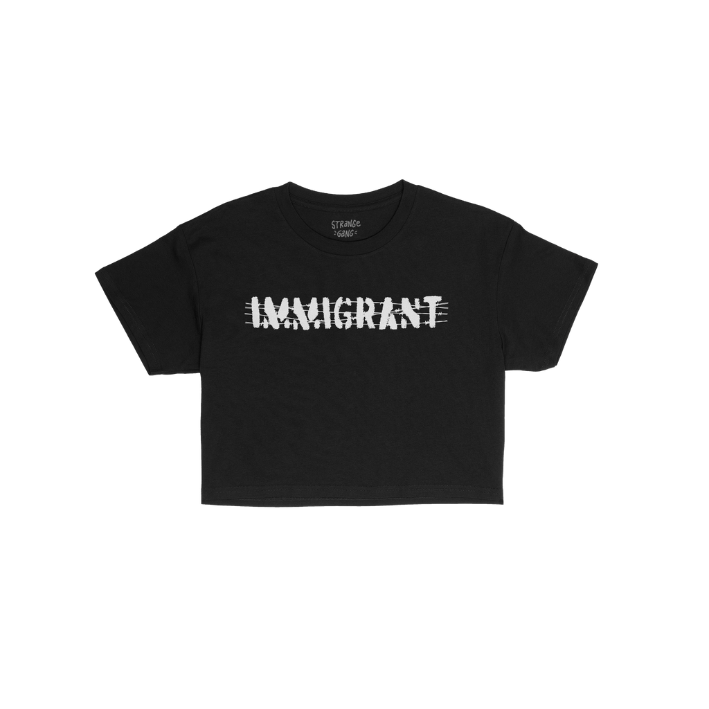 Immigrant Women's Baby Tee featuring distressed white IMMIGRANT text with slash marks on black fabric, symbolizing strength a