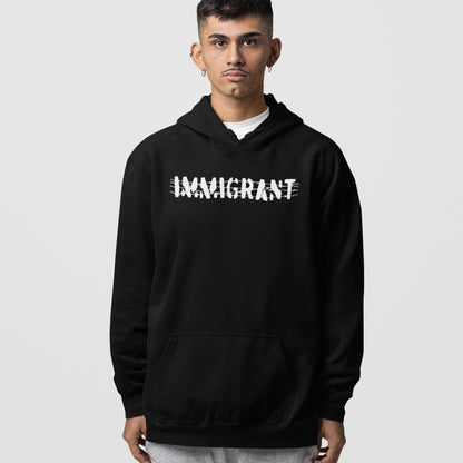 Young man wears the Immigrant Shirt hoodie, featuring bold white lettering crossed out with scribbles, symbolizing resilience and unity.