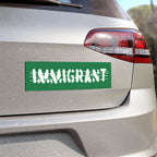 Immigrant Sticker & Magnet on a silver hatchback's bumper, featuring bold IMMIGRANT text with barbed-wire effect, symbolizing pride and resilience against anti-immigrant sentiment.