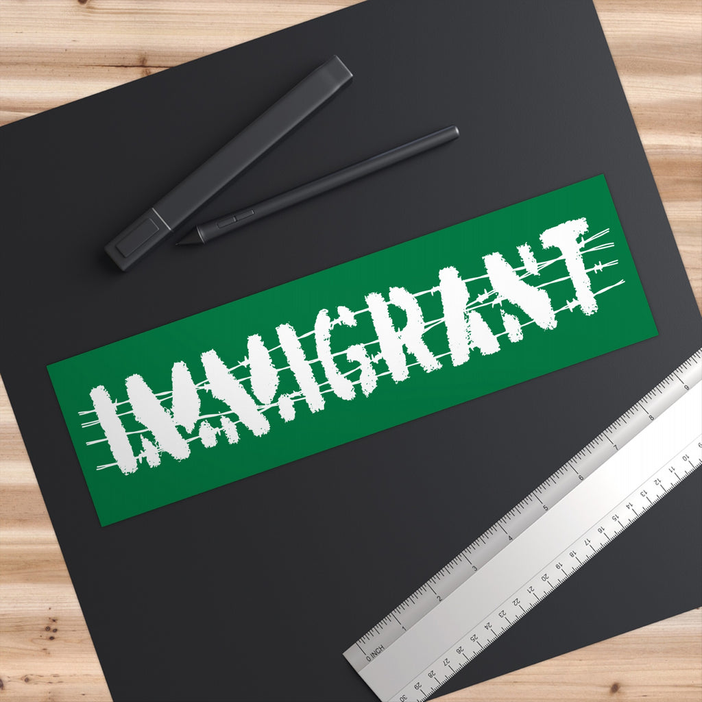 Overhead view of Immigrant Sticker & Magnet on a black mat, showcasing the word MAINCRAFT in a distressed style, paired with a digital stylus and metal ruler, embodying a bold, empowering message.