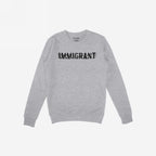 Light-grey Immigrant Hoodie & Sweatshirt features bold, distressed IMMIGRANT lettering with slash-through style, embodying activism and solidarity. Small label on neckline enhances its statement-making design. Unisex fit encourages unity.