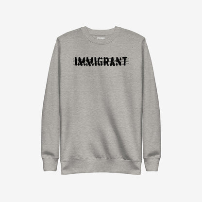 Light-grey Immigrant Hoodie & Sweatshirt features bold, distressed IMMIGRANT lettering with slash-through style, embodying activism and solidarity. Small label on neckline enhances its statement-making design. Unisex fit encourages unity.
